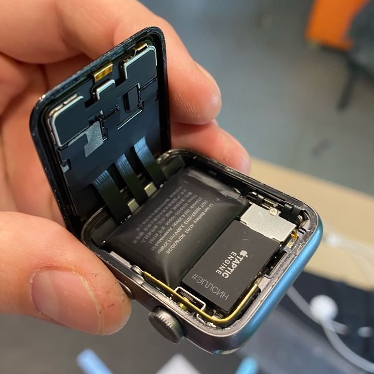 Apple Watch abierto con la pantalla levantada y la batería a la vista