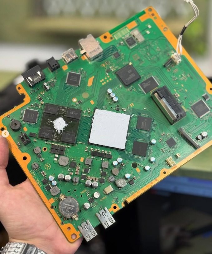 Placa de PlayStation con pasta térmica nueva sobre el procesador